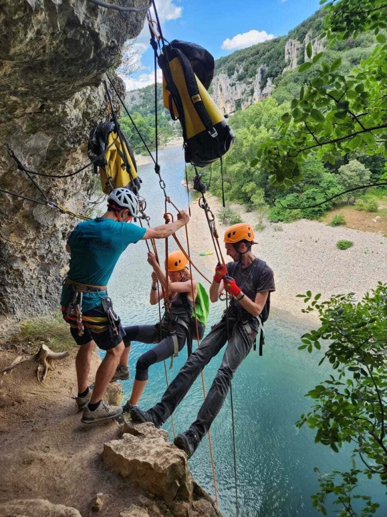 Guide accompagnant des clients sur une via corda dans les gorges de l’Ardèche au bord de la rivière. Activité phare des clients de la location courte durée à vallon pont d'arc par la conciergerie en Sud Ardèche.